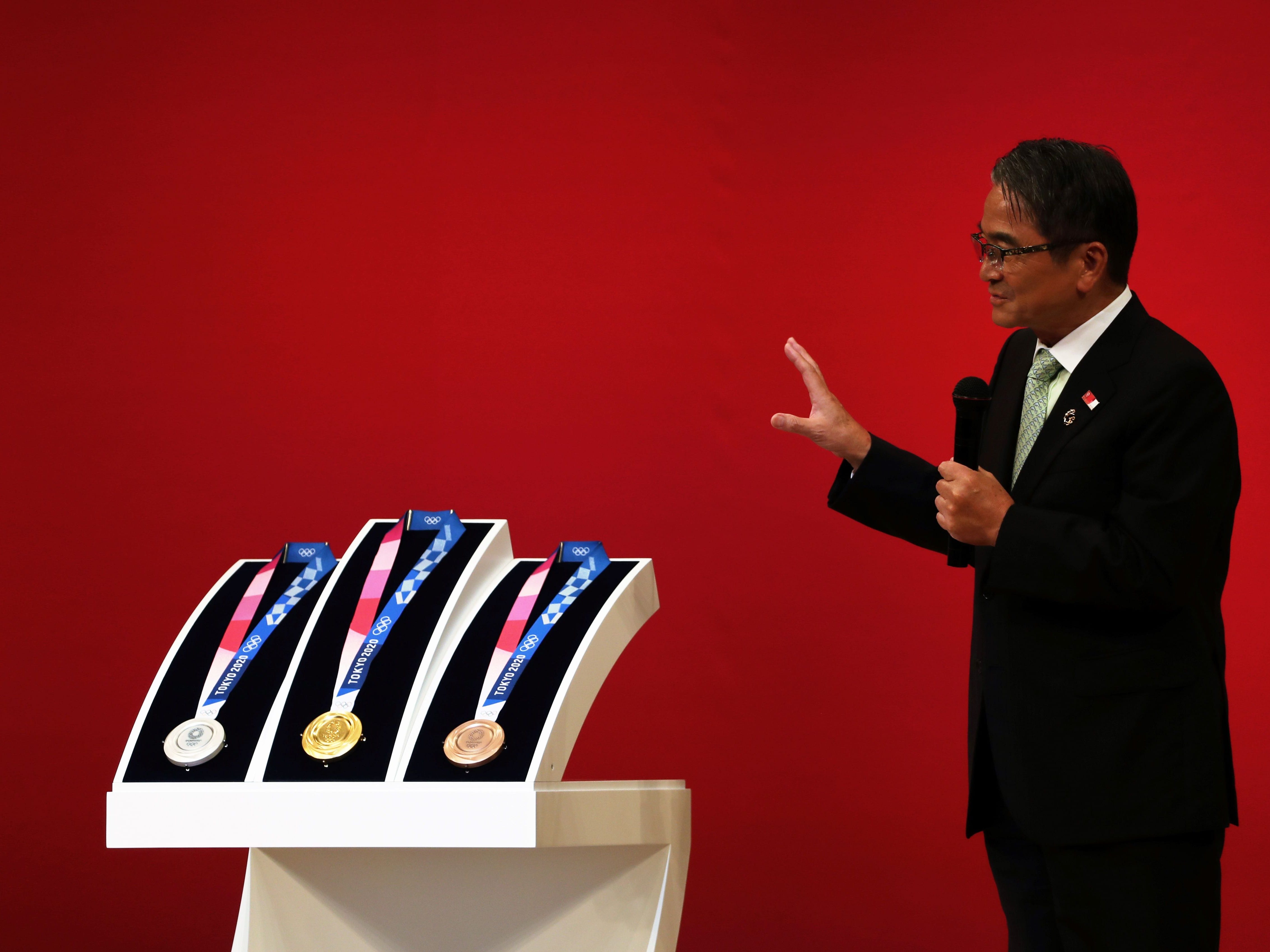 The medals for the Tokyo 2020 Olympic Games are unveiled as Ryohei Miyata, commissioner for cultural affairs and Tokyo 2020 medal design competition panel chairperson, speaks during a ceremony marking one year before the start of the games in Tokyo on July 24, 2019.