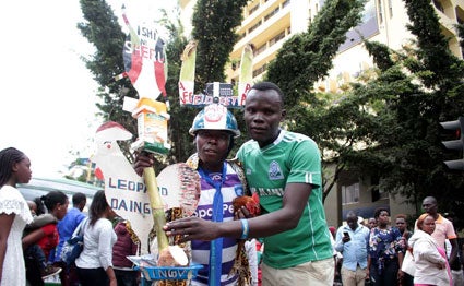 A Gor Mahia fan sand an AFC Leopards' fan pose for photos along Moi Avenue, Nairobi on November 10, 2019 ahead of the Mashemeji Derby. PHOTO | SILA KIPLAGAT | 