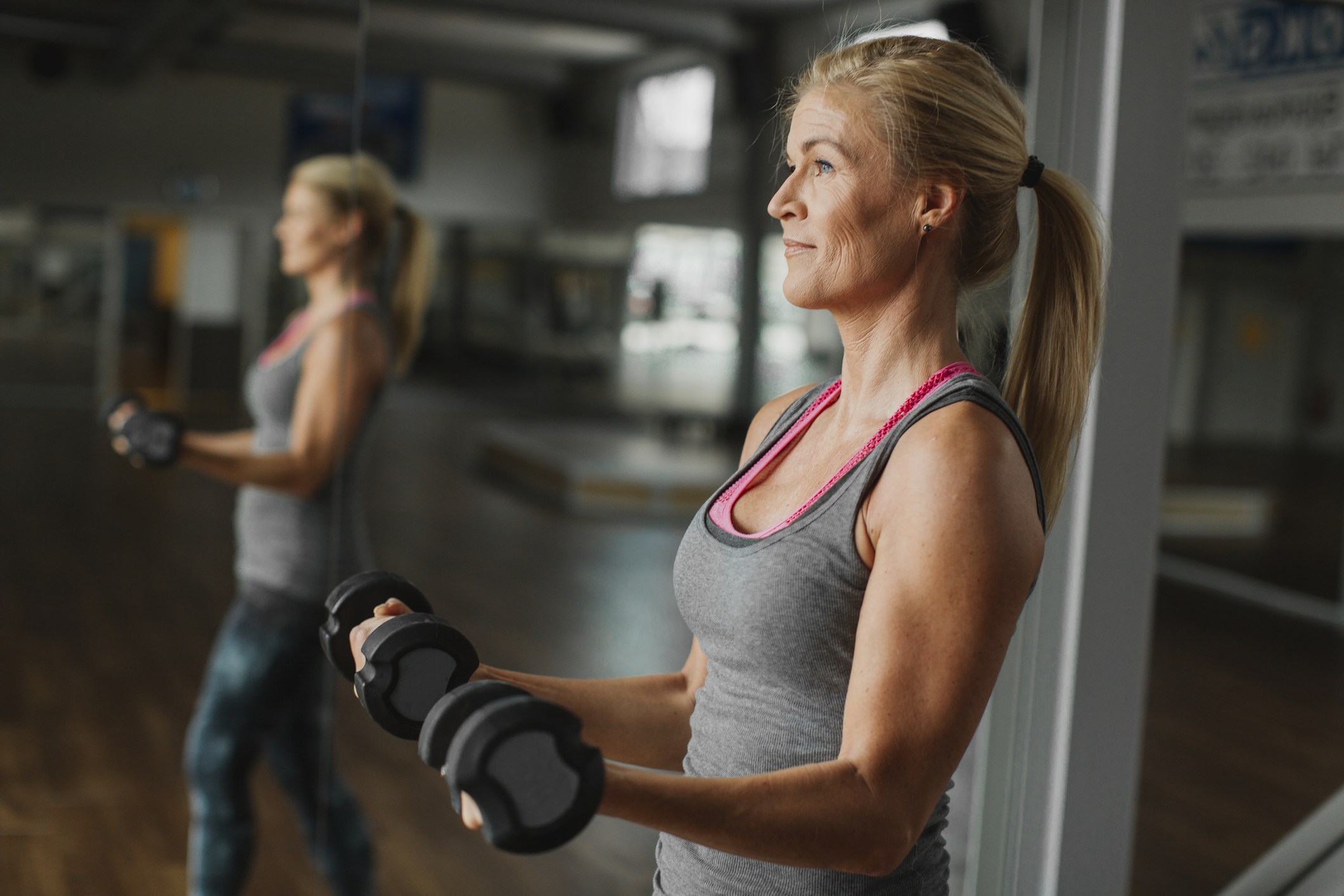 Woman exercising with dumbbells in gym