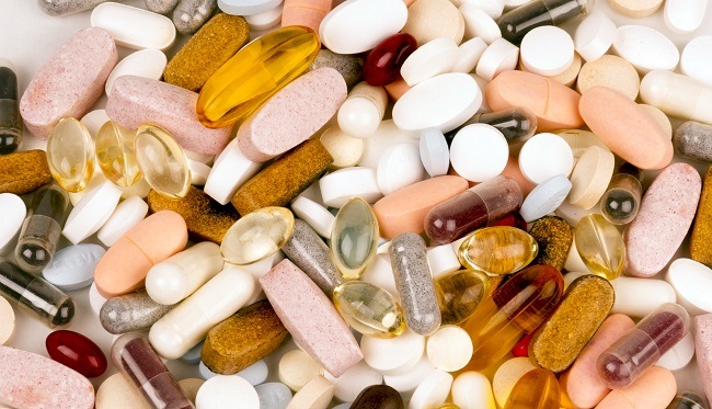 Pile of vitamin supplements of different colours and shapes. 