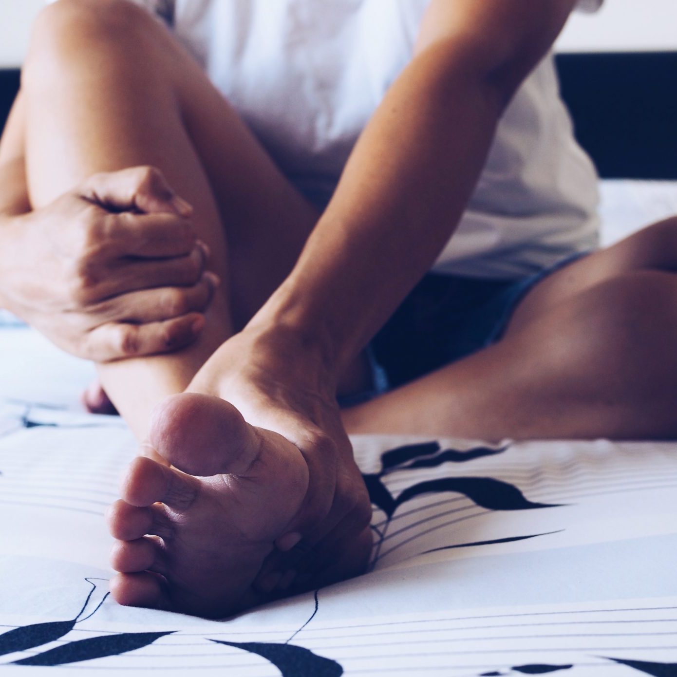 woman holding foot because of foot pain tendonitis from bad shoes