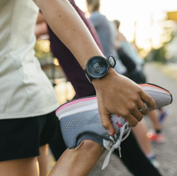 A close up of a woman stretching her legs before going on a run through the city.