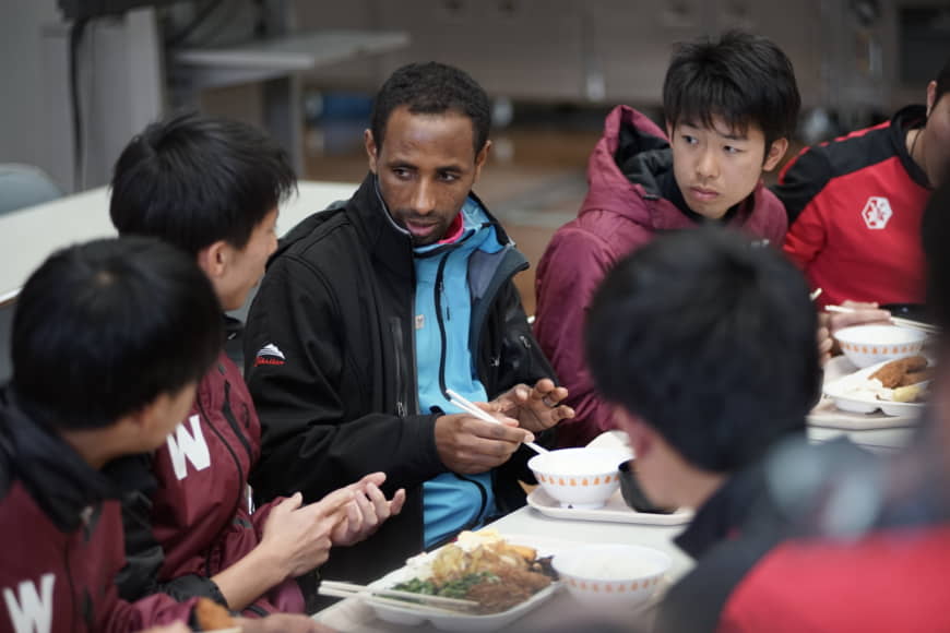 Yonas Kinde, a 39-year-old Ethiopian refugee preparing to compete in the Tokyo Marathon, shares a meal with long-distance runners from Waseda University's track and field team at its satellite campus in Tokorozawa , Saitama Prefecture. | RYUSEI TAKAHASHI