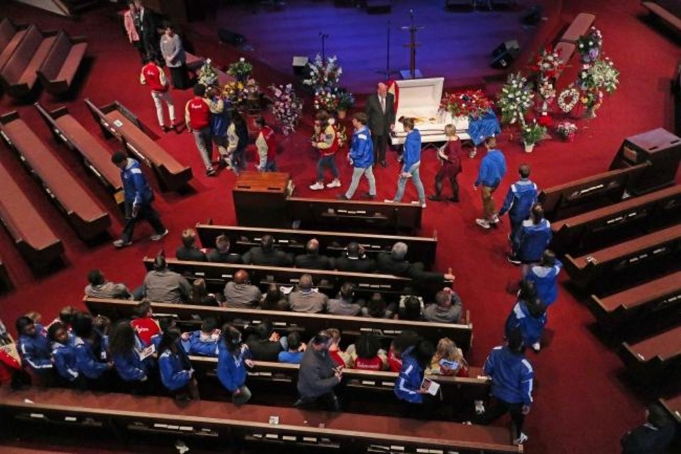 Photo - Members of the Moore High School track team file past Rachel Freeman's casket. She was one of three distance runners killed by a drunk driver three months ago. The team rallied together after the incident, and even though the coronavirus pandemic has kept them physically apart, they continue to lean on each other. [DOUG HOKE/THE OKLAHOMAN] 