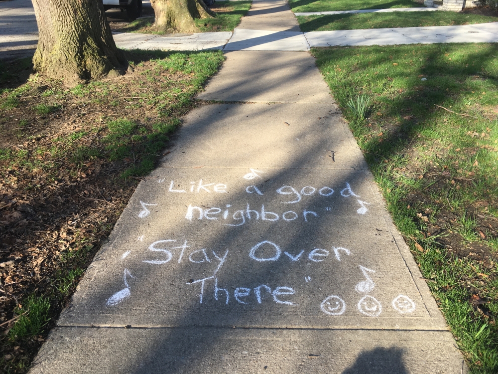 Coronavirus distancing graffiti reads "Like a good neighbor, stay over there"