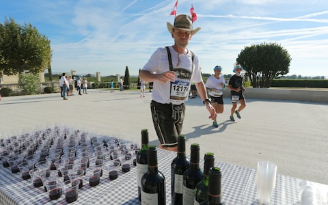 A runner stops for a wine break in the courtyard of Chateau Montrose, near Pauillac
