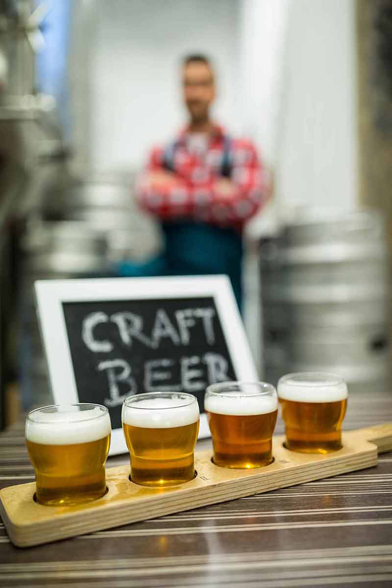 fun things to do in lancaster pa Close-up of four glasses of craft beer on beer sampler tray at brewery.