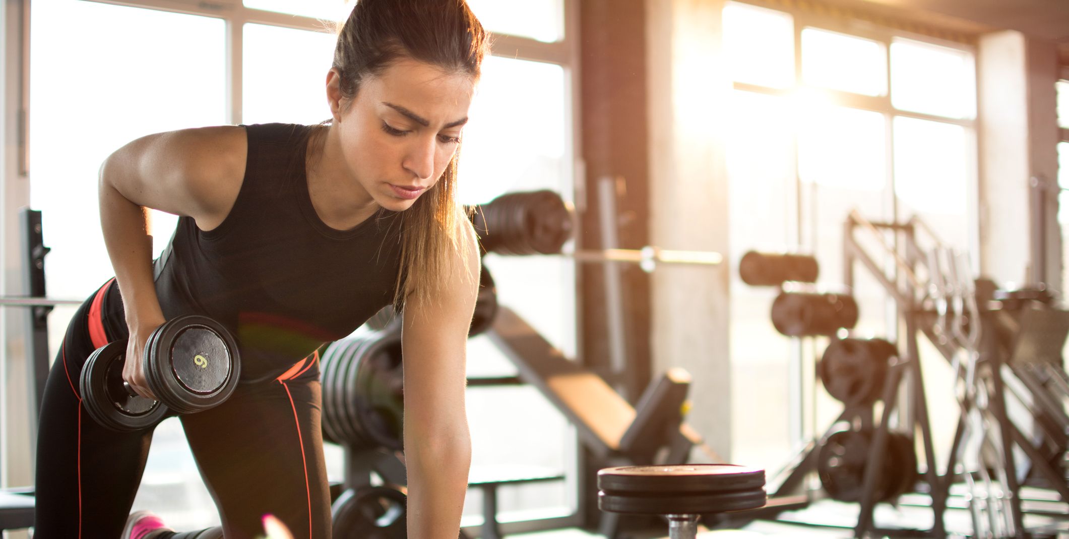 Fitness girl lifting dumbbell in the morning.