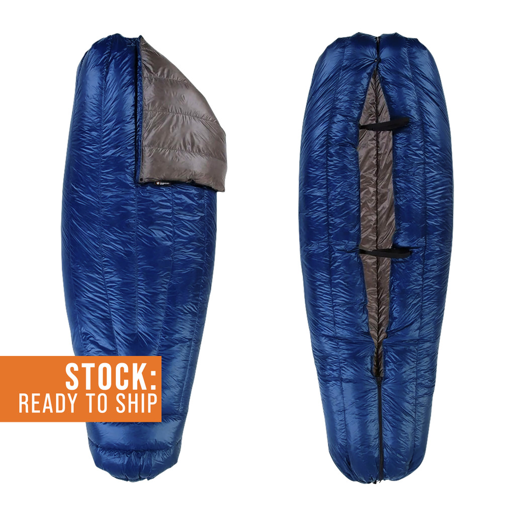 slightly open view of a navy blue shell lightweight down sleeping bag quilt with a charcoal gray interior 