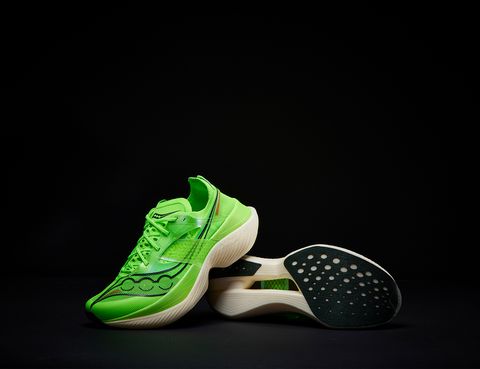 lime green saucony endorphin elite shoes laid over a black background