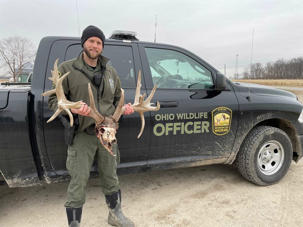 A wildlife officer holds up a set of antlers.