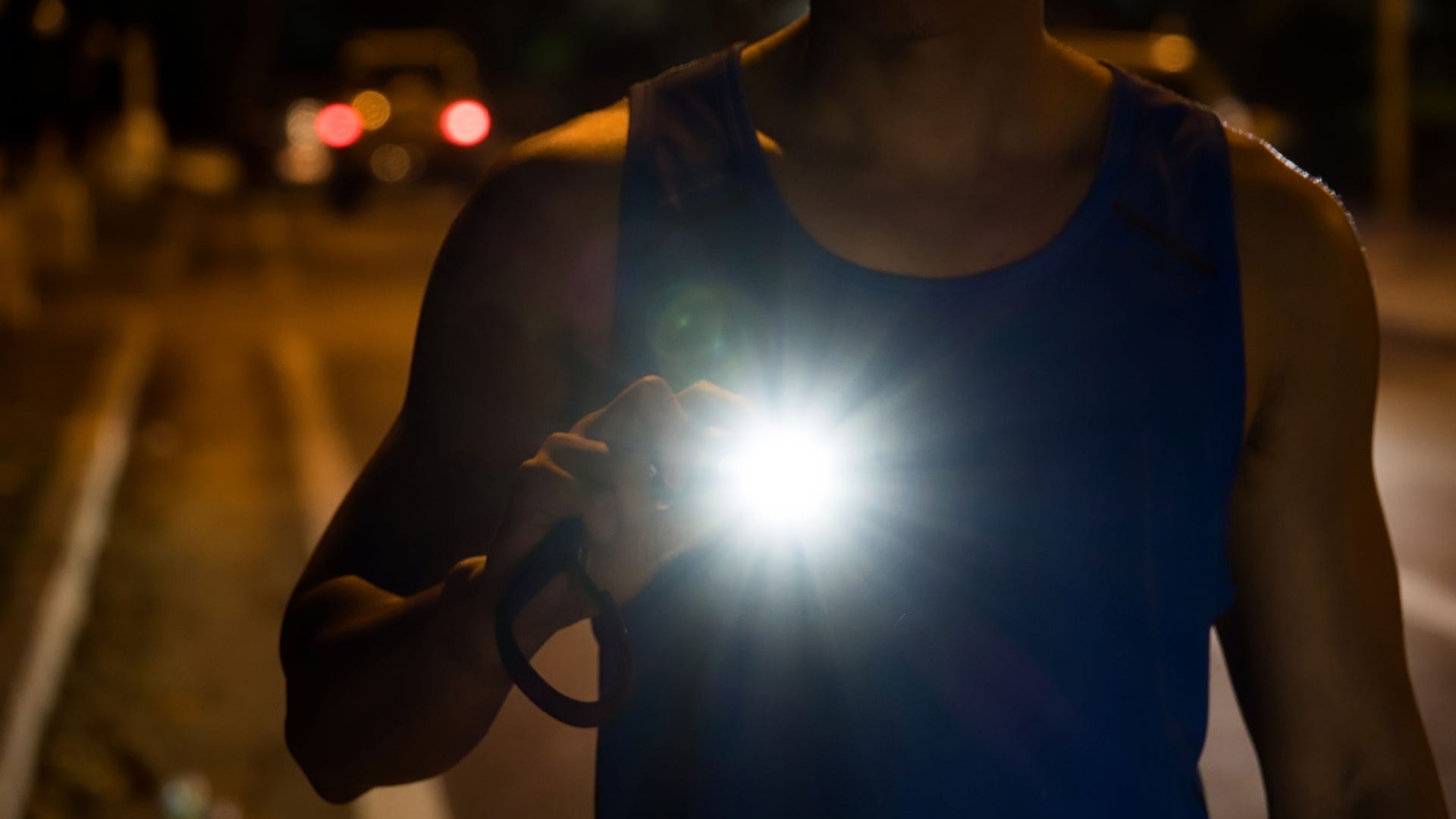 A runner with a light at his chest in the dark.