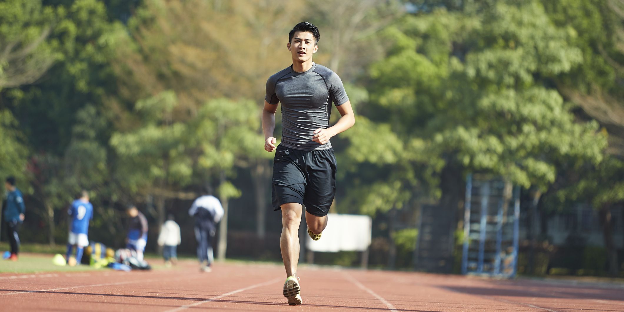 young asian athlete training on running track